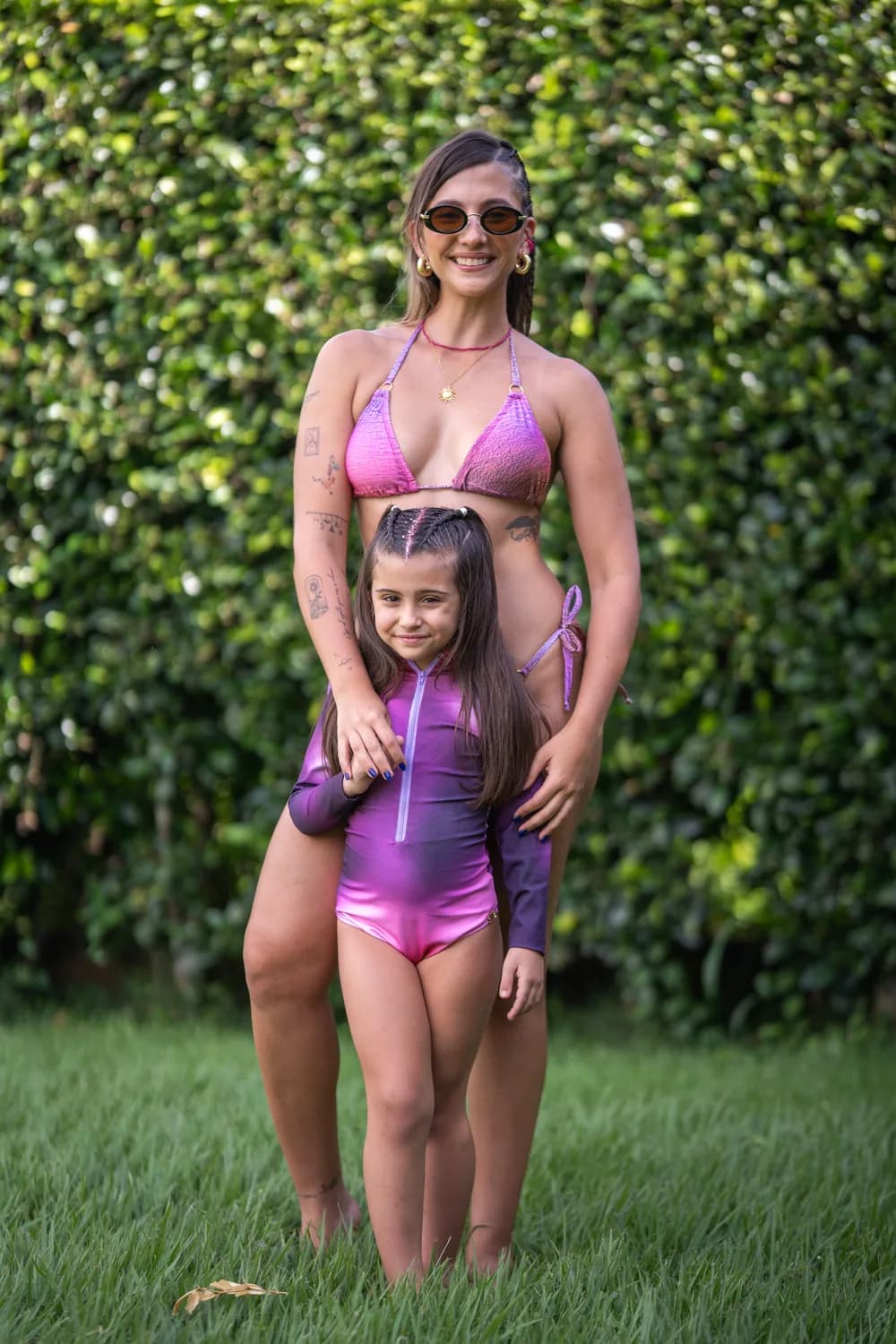 Mujer y niña con trajes de baño coordinados en un jardín